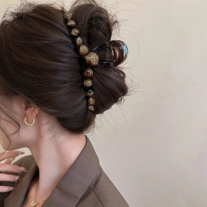 Grande molletta per capelli marmorizzata sfumata indossata per uno chignon raffinato