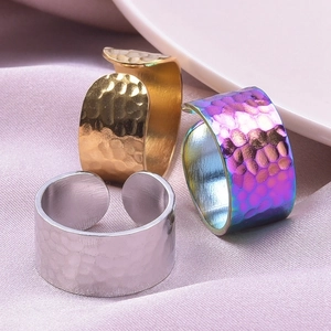 Detailed view of wide hammered texture rings in gold, silver and rainbow gradient steel