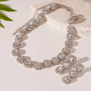 Close-up of luxury silver jewelry set with sparkling square and round rhinestones