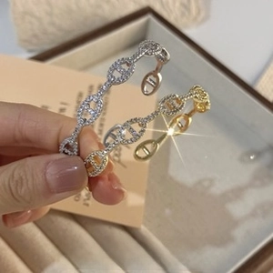 Detailed view of silver and gold pig nose link bracelets with pavé diamond accents