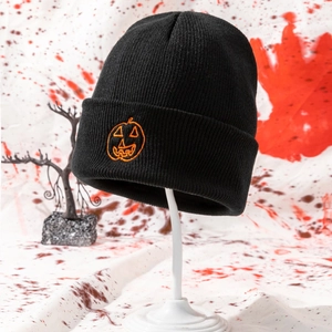 Close-up of black knitted beanie featuring orange pumpkin embroidery and folded cuff