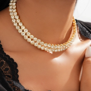 Close-up of double layer gold tennis necklace with sparkling round cut crystals on model