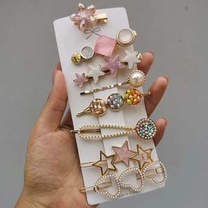Detail view of 8-piece pink and gold hair clip set with pearls and rhinestones