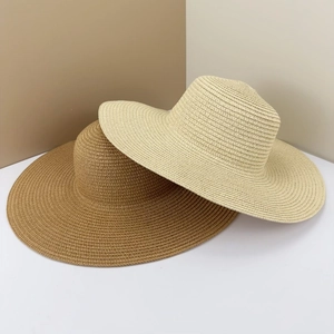 Vista dettagliata di due eleganti cappelli da sole in paglia a tesa larga beige e kaki.