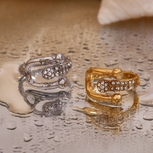 Dettaglio di anelli a fibbia in oro 18 carati e argento con micro-pavé di cristalli