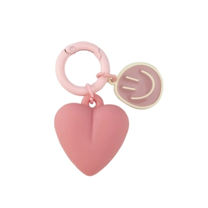 Pink heart-shaped keychain with cartoon smiley face charm and matching pink metal ring