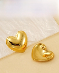Detailed view of polished 18k gold plated stainless steel heart-shaped stud earrings