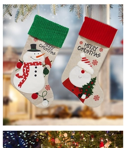 Detail of linen Christmas stockings with Santa, snowman and Merry Christmas embroidery