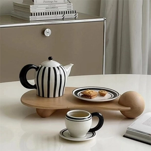 Vintage black and white striped tea set with teapot, cups, and wooden ball-foot tray