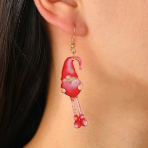 Detail view of a cute acrylic gnome earring with red hat and pink heart worn by a model
