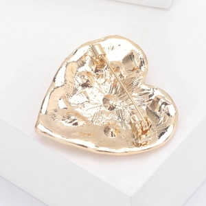 Vintage heart shaped gold brooch with secure pin clasp shown from a rear perspective