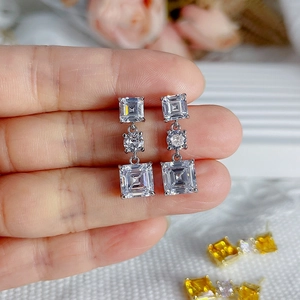 Vue macro de boucles d'oreilles pendantes en argent avec trois zircons carrés et ronds
