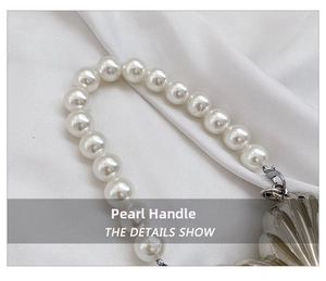 Detailed macro view of the pearl handle attached to a shell-shaped metal evening bag