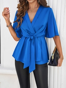 Détail du haut élégant bleu roi à col en V avec taille nouée et manches demi-longueur
