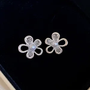 Elegant silver floral earrings with mesh petals and center pearl on black background