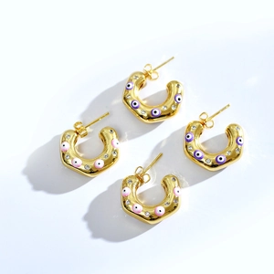 Polished C-shaped gold earrings featuring colorful enamel evil eye and sparkling zircons