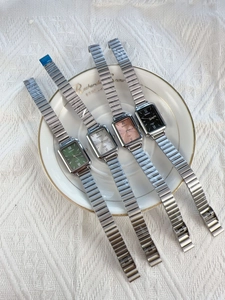 Four elegant rectangular quartz watches with bamboo-style metal straps in various colors