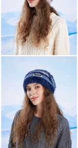 Detail view of winter knitted beanie with brand patch and ribbed texture on mountain background
