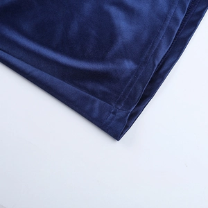 Détail macro de l'ourlet de la robe bleu marine montrant couture et texture du tissu