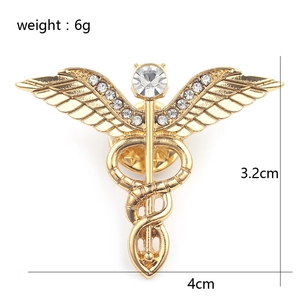 Goldene Caduceus Brosche mit Flügeln und Schlangen zeigt Maße 4cm Breite und 3,2cm Höhe