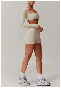 Rear view of a premium cream three-piece yoga set featuring a zip-up jacket and biker shorts
