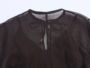 Detail of bohemian chiffon dress neckline with adjustable drawstrings and metal beads