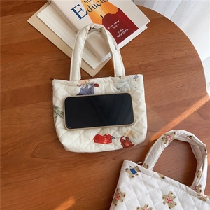 Detailed close-up of quilted cotton phone pouch with cartoon prints and size reference