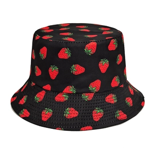 Détail du chapeau bob noir montrant l'imprimé fraise et la texture du coton sergé