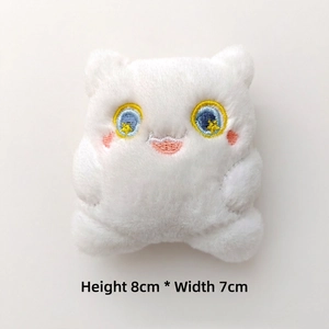 Detail view of a white plush monster doll showing 8x7cm dimensions and embroidery details