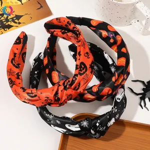 Detail of Halloween knotted headbands with pumpkin and ghost prints on a white table