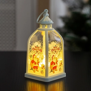 Close-up of white Christmas lantern with Santa Claus illustration and warm LED light