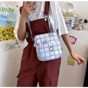 Detail of white plaid crossbody bag with cute bunny and heart patterns for students