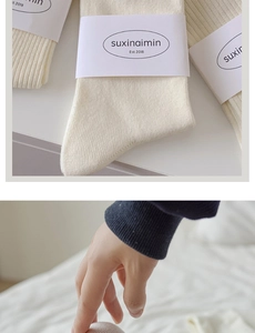 Detail of off-white ribbed knit socks showing soft texture and premium packaging labels