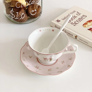 Detail of ceramic pink rose coffee cup with saucer and spoon for elegant tea time