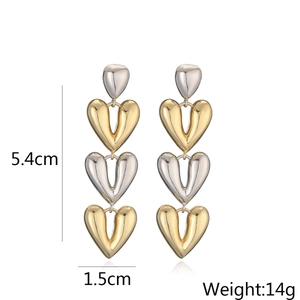 Detail view of heart-shaped gold and silver earrings with dimensions 5.4cm and weight 14g
