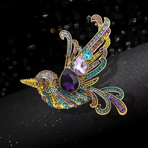 Golden hummingbird brooch with multi-color rhinestones and purple pear-cut gemstones