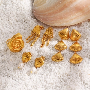 Golden starfish seashell earrings set with pearls and ocean-themed jewelry on white shells