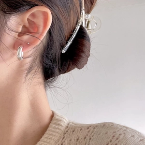 Minimalist S925 sterling silver C-shaped hoop earrings worn by a model in soft lighting