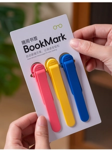 Close-up of three colorful silicone bookmarks held by hand with page tracking feature