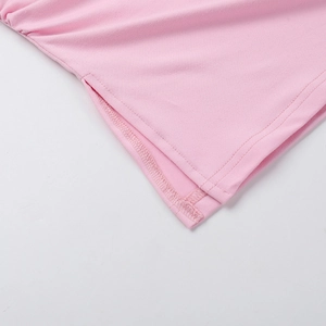 Détail du haut en maille rose avec fente latérale et coutures de précision soignées