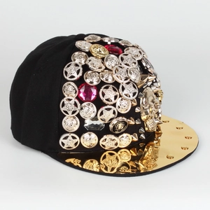 Detail of hip hop snapback with gold rivets, skulls, and colorful gemstones on black crown