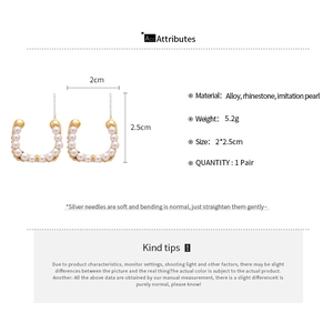 Detail view of C-shaped pearl earrings with gold base and dimensions 2x2.5cm