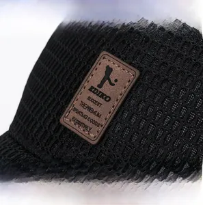 Gros plan d'un écusson en cuir marron cousu sur un tissu en maille noire respirante