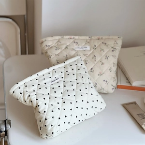 Detailed view of quilted corduroy makeup bags with heart and floral patterns and cloth label