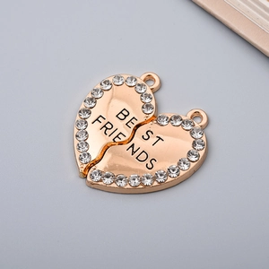 Golden heart-shaped metal pendants with rhinestones and BE FRIENDS engraving