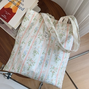 Dettaglio ravvicinato della borsa shopper in cotone a fiori con strisce ed etichetta tessuta