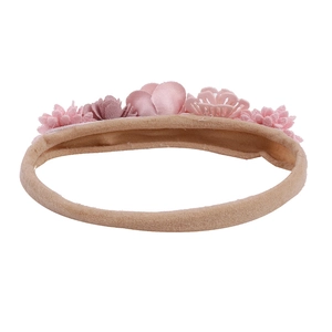 Close-up of pink handmade fabric flowers on a soft elastic baby headband accessory