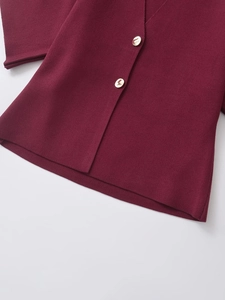 Detail view of burgundy V-neck knit cardigan featuring elegant gold metal buttons