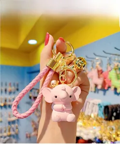 Close-up of pink elephant keychain with pearl crown and braided leather strap