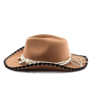Detail of felt cowboy hat with woven bohemian band featuring white beads and shell accents